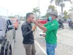 Ketua dewan penasehat gp. Ansor, minduchri kudubun, menyematkan masker medis kepada ketua dprd kota tual, hasan syarifudin borut, yang melintasi jembatan usdek, rabu sore ( 24/12/2020 )