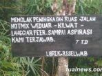 Pemasangan papan kayu dengan tulisan menolak peningkatan jalan hotmix weduar – kilwat langgiar feer yang melewati tutrean